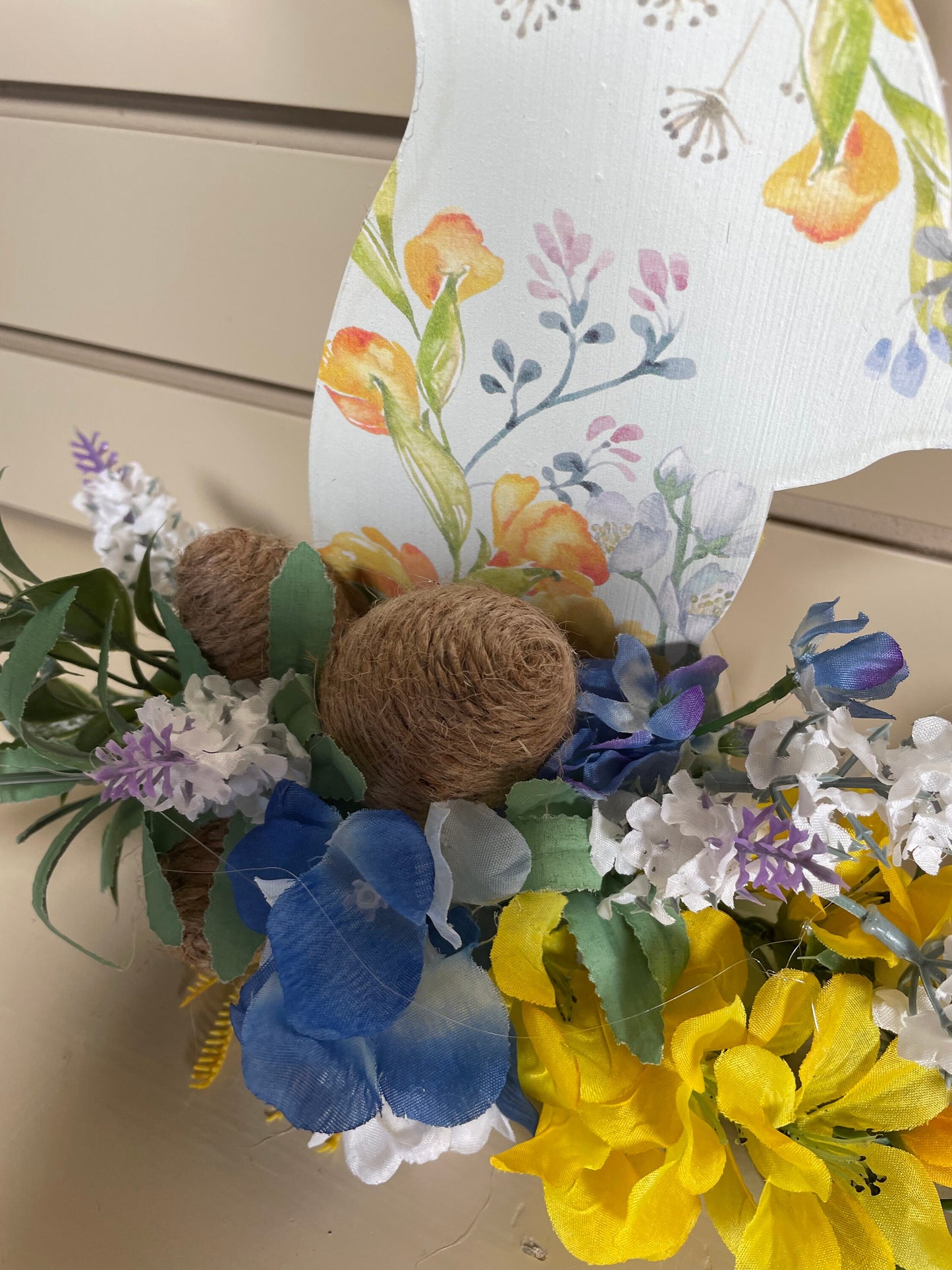 Set of 3 Wooden Standing Painted Easter Bunnies embellished with Blue, Yellow, and Lavender Flowers and Greenery for Easy Holiday Decor.
