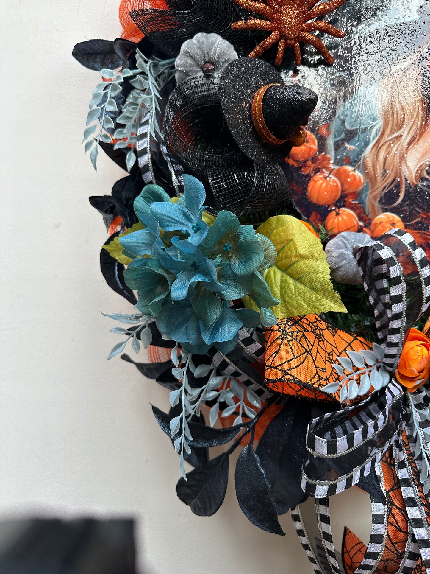 Wreath with glam witch sign, pumpkins, spider, witch hats and blue leaves gives a dark and moody Halloween vibe and add magic to your door.