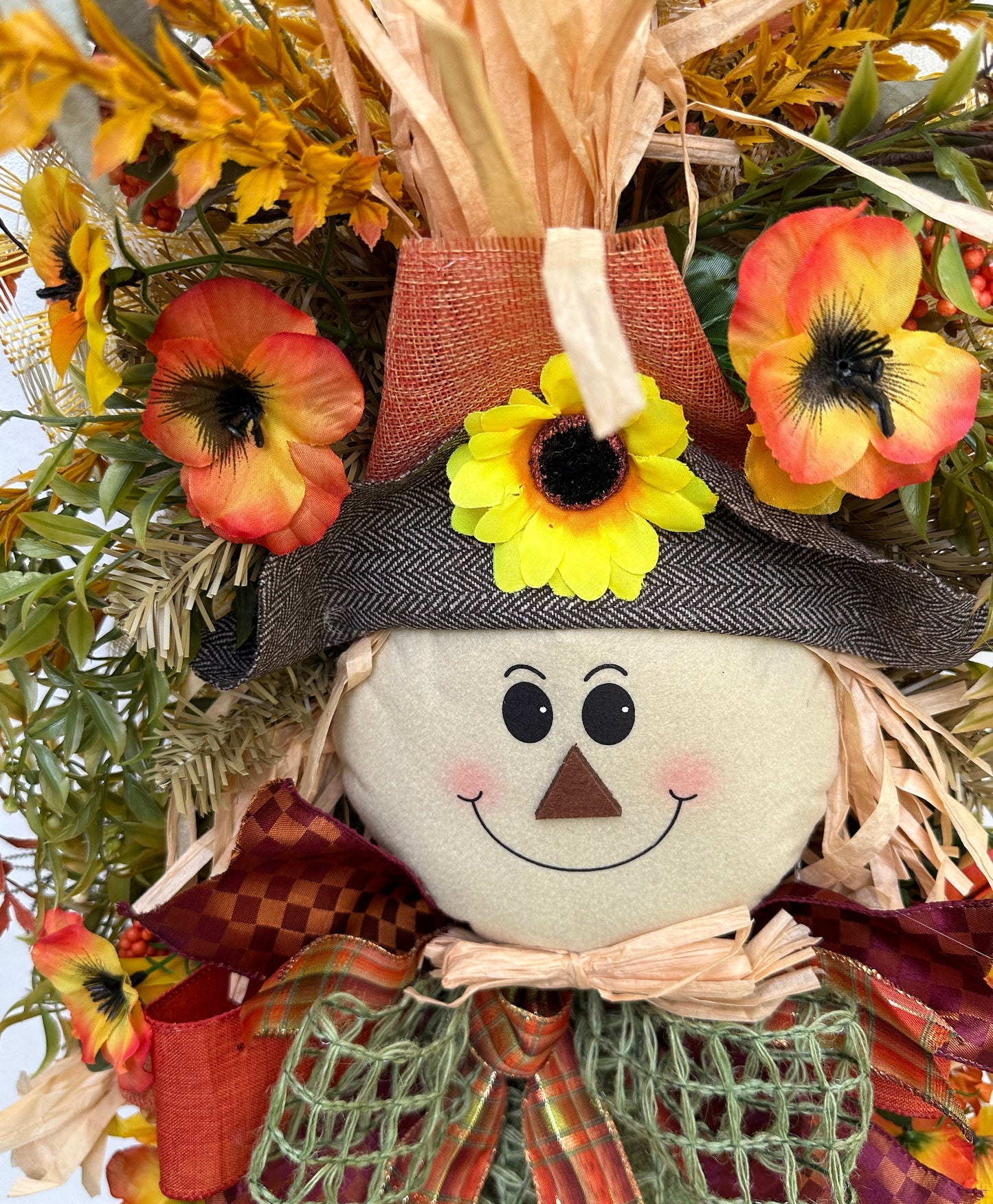 A Fall Large Smiling Scarecrow Wreath with Autumn Foliage and Festive Ribbons is the perfect Harvest, Thanksgiving or Halloween Decor