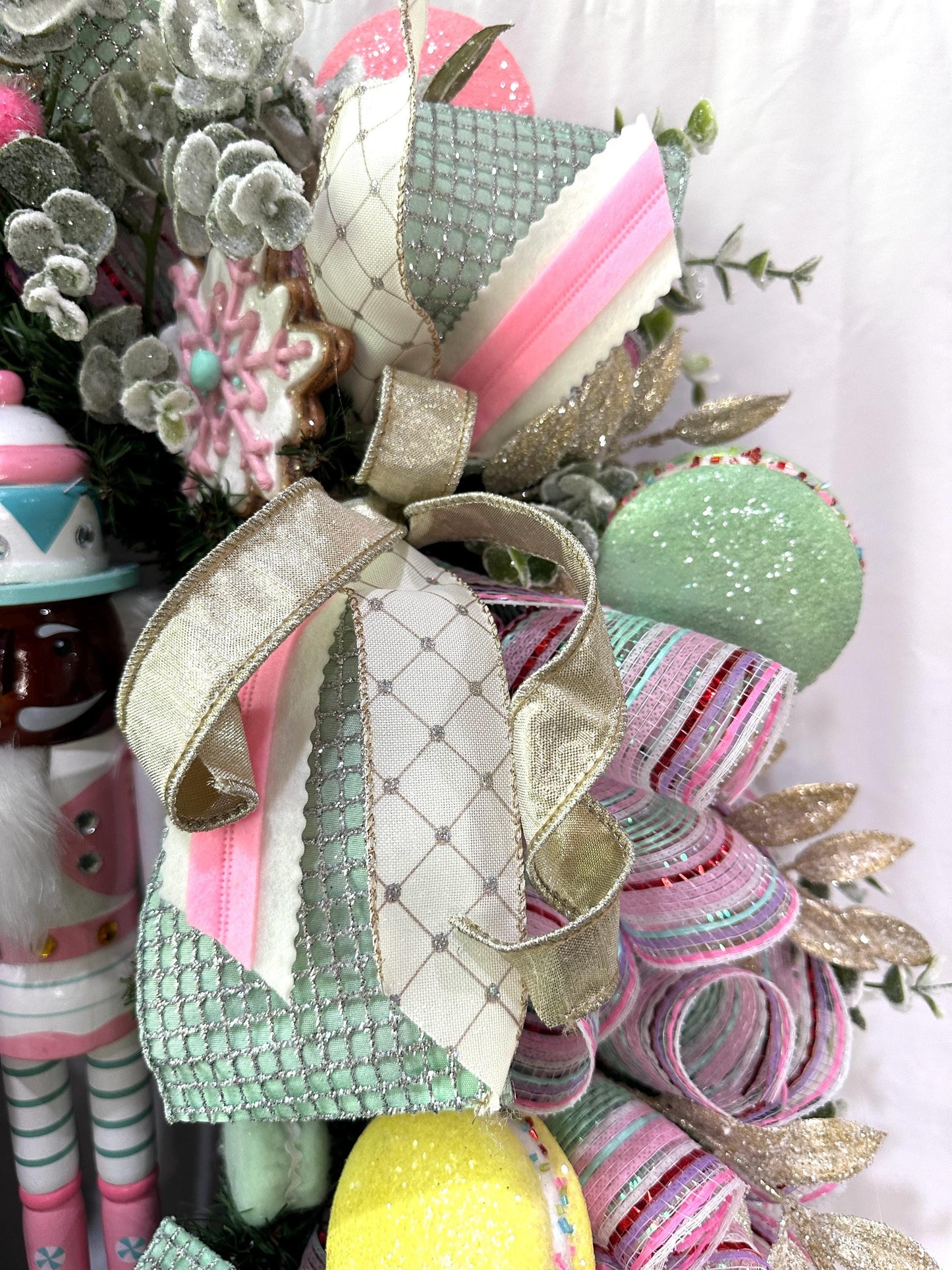 Candyland themed pink and mint green nutcracker Christmas wreath in pastel colors with dark face or light face soldier and sweet treats