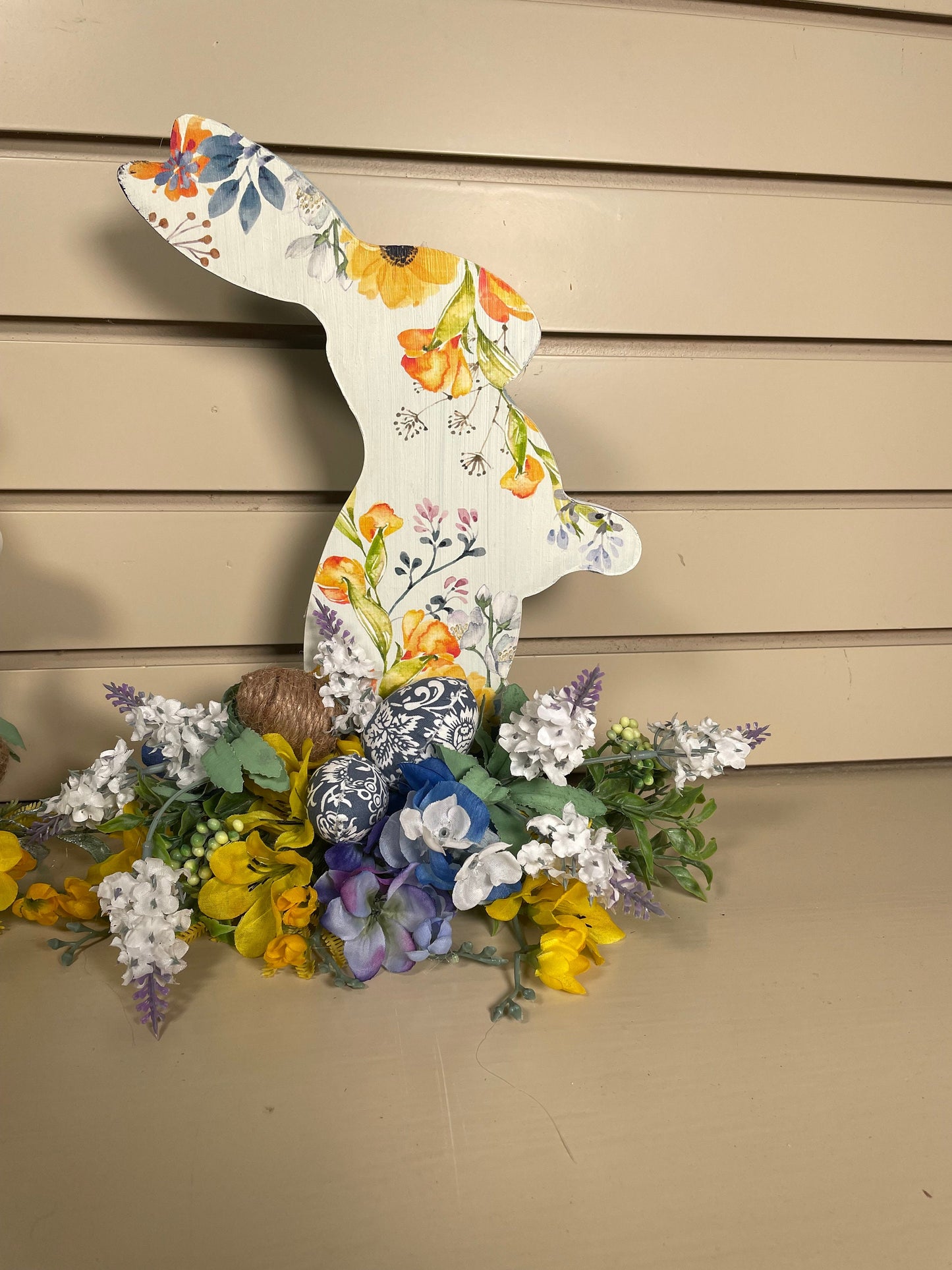 Set of 3 Wooden Standing Painted Easter Bunnies embellished with Blue, Yellow, and Lavender Flowers and Greenery for Easy Holiday Decor.