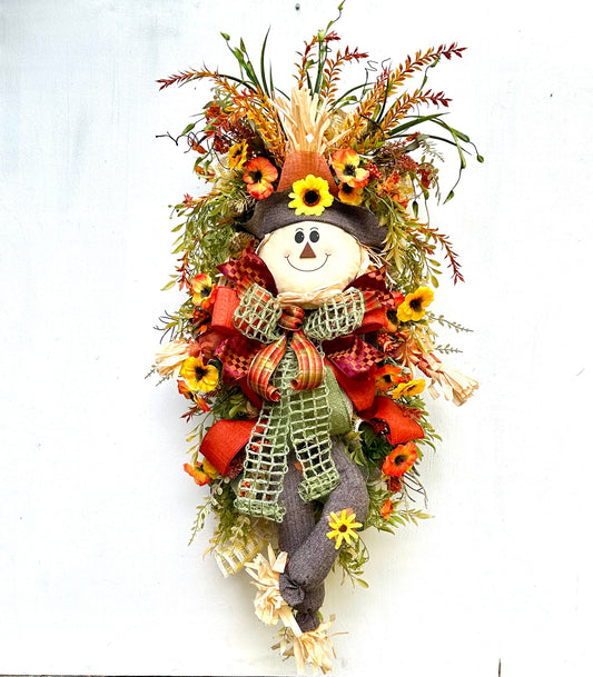 A Fall Large Smiling Scarecrow Wreath with Autumn Foliage and Festive Ribbons is the perfect Harvest, Thanksgiving or Halloween Decor