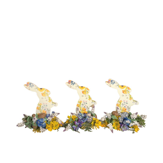 Set of 3 Wooden Standing Painted Easter Bunnies embellished with Blue, Yellow, and Lavender Flowers and Greenery for Easy Holiday Decor.