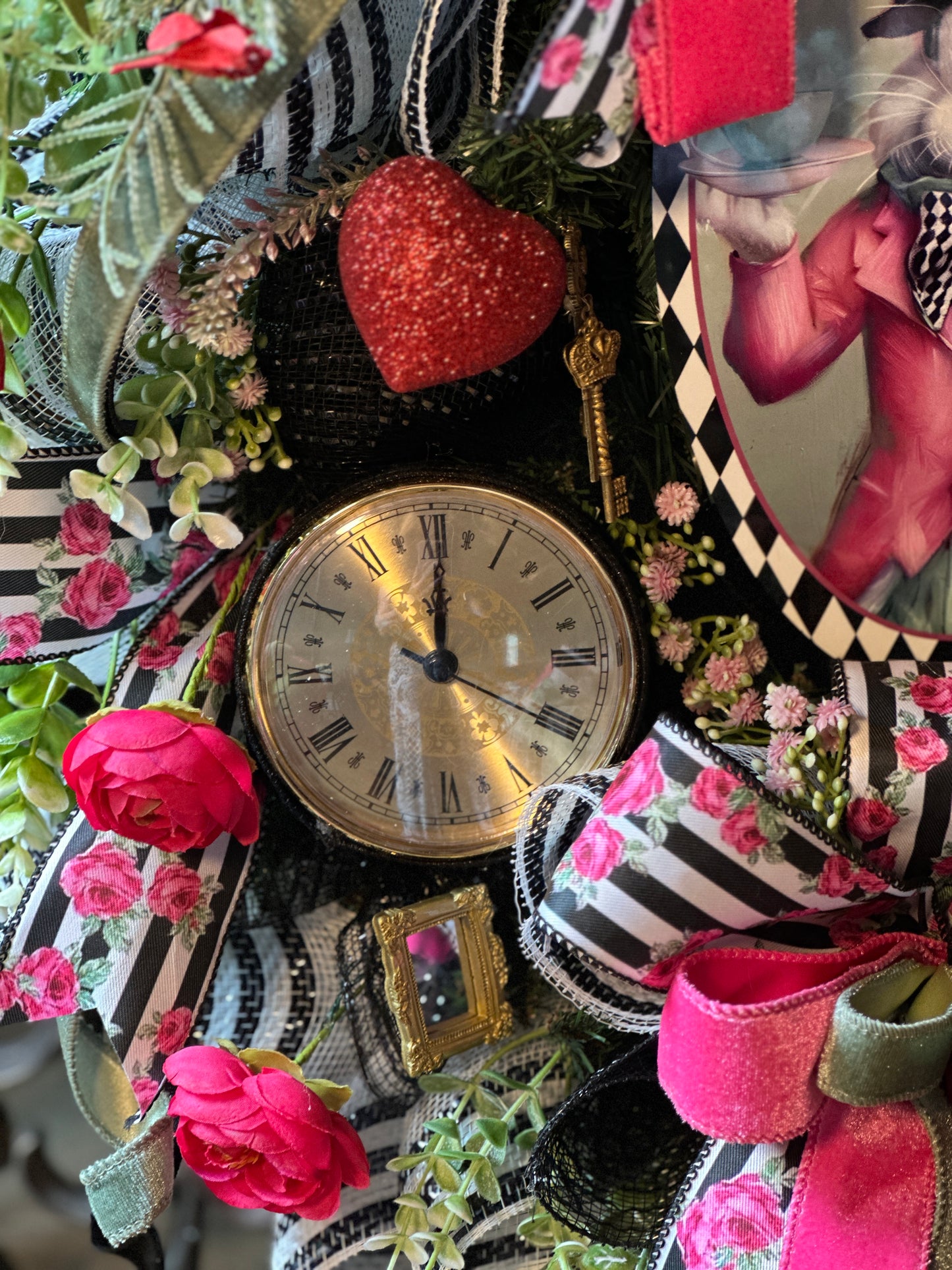 Decorative wreath with clock, flowers, and ribbons on a black and white striped background