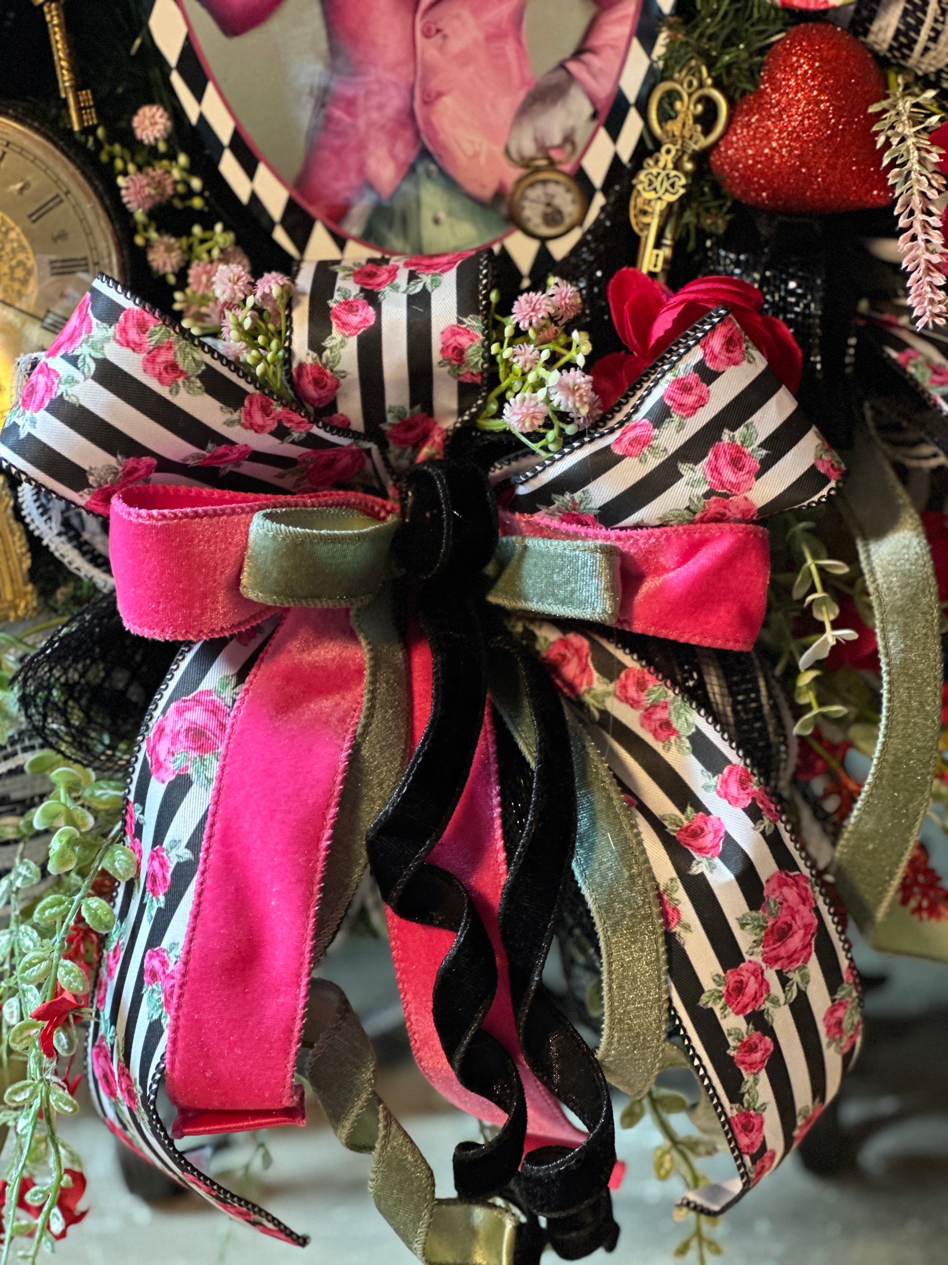 Decorative bow with pink, black, and gold ribbons on a floral background