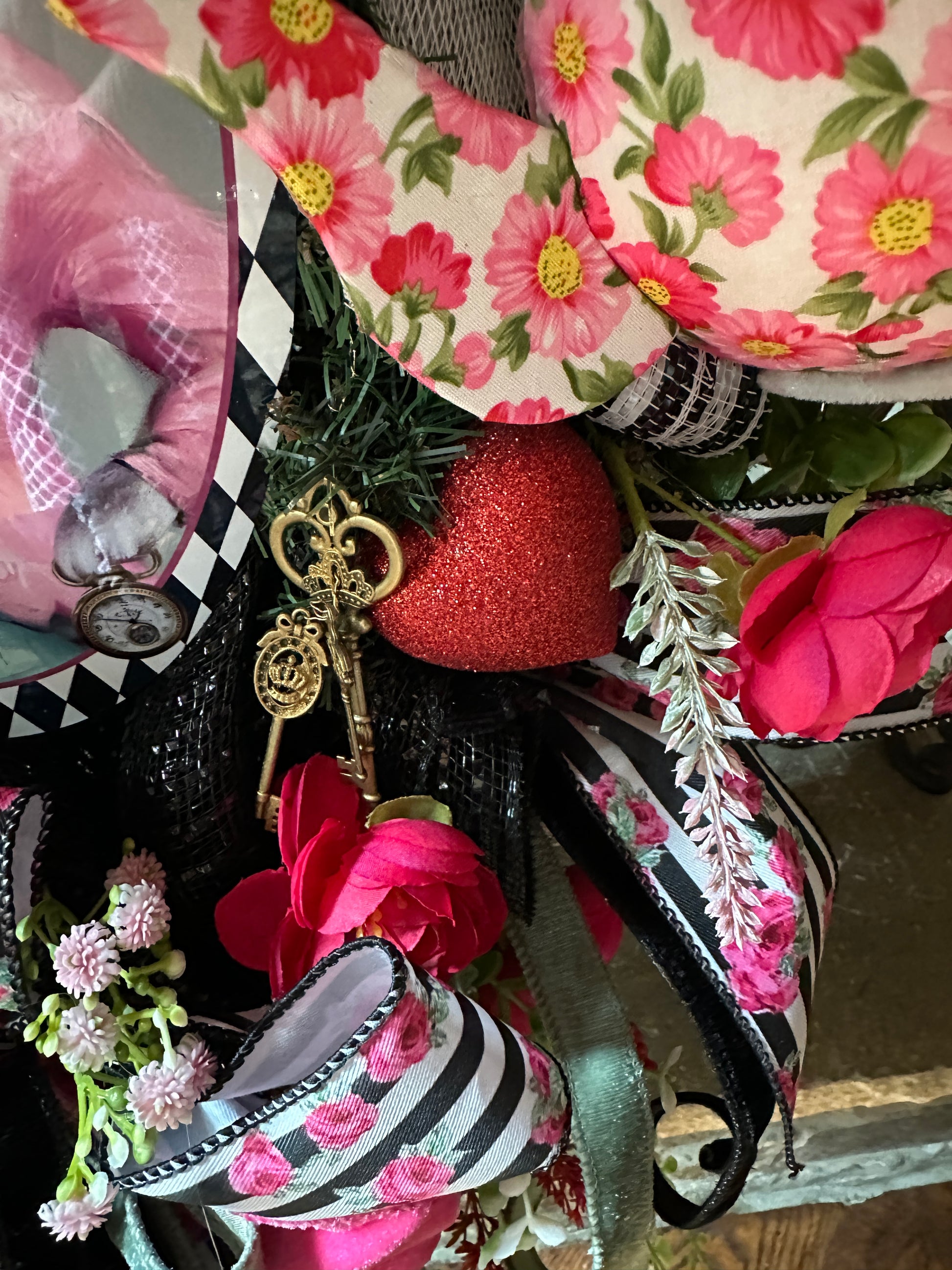 Decorative wreath with flowers, ribbons, and keys on a checkered surface