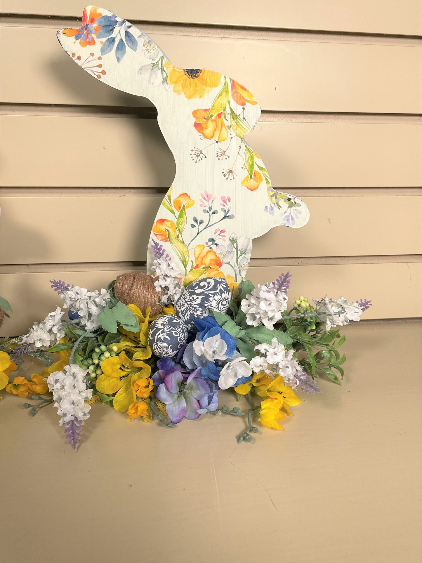 Set of 3 Wooden Standing Painted Easter Bunnies embellished with Blue, Yellow, and Lavender Flowers and Greenery for Easy Holiday Decor.